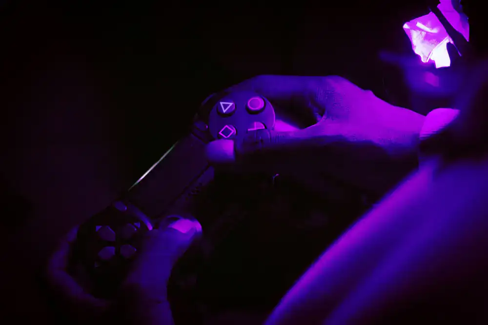 Player hands holding a smartphone in landscape mode playing a colorful game
